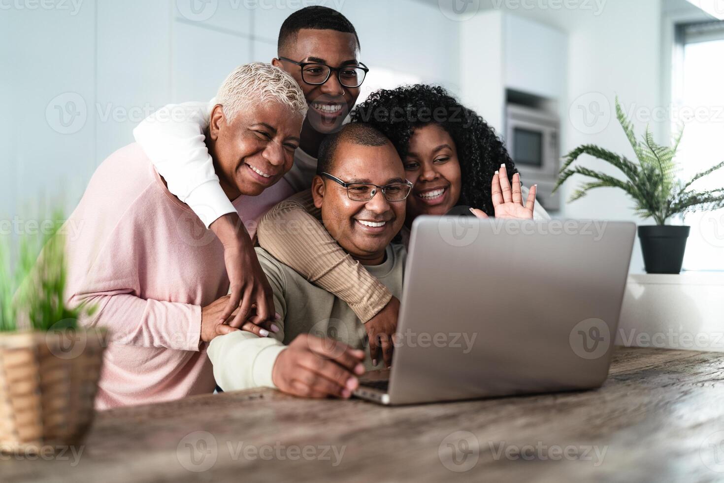 Happy Hispanic family having fun doing video call with parents using laptop at home  - Technology and communication concept photo
