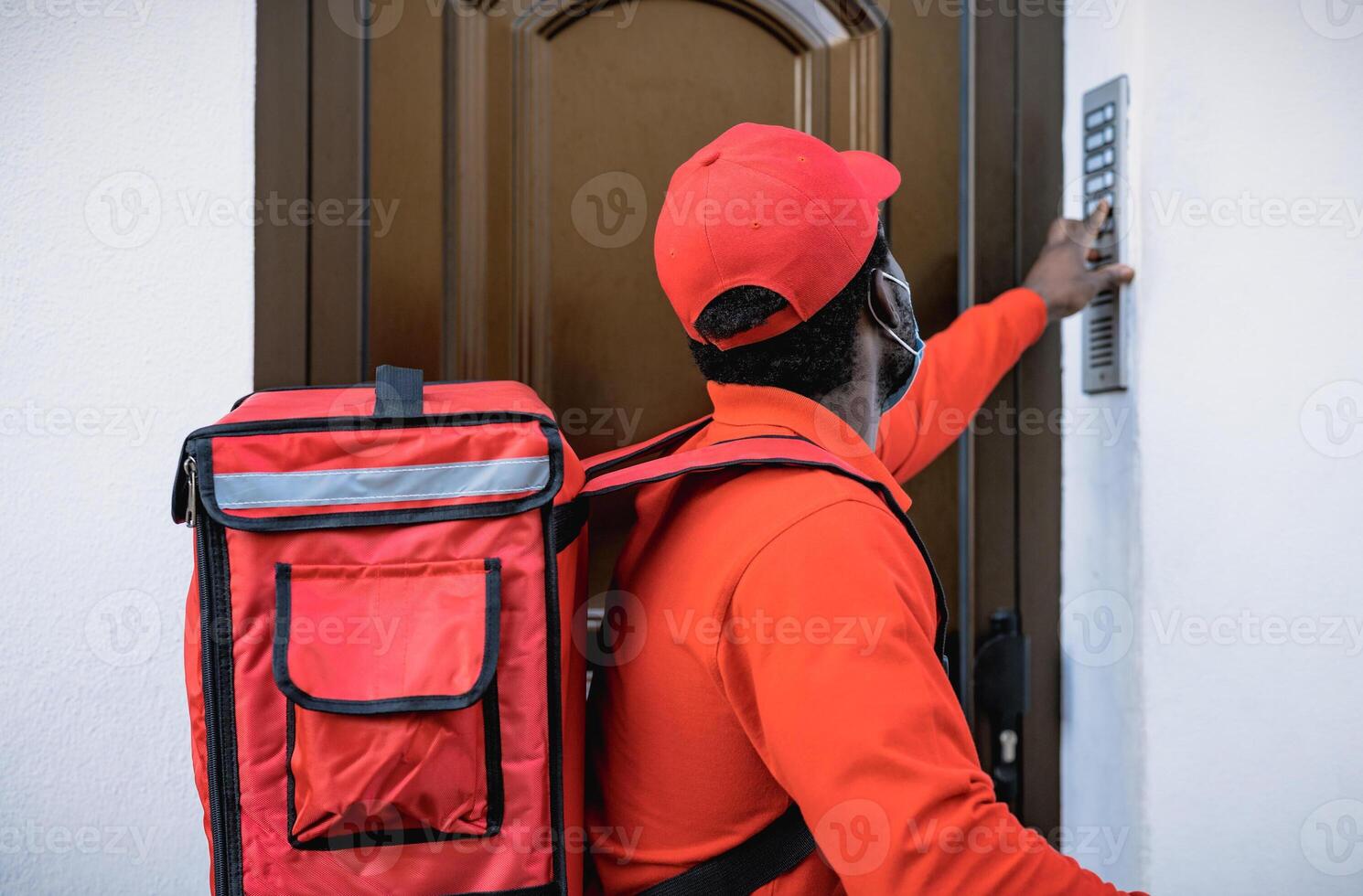 African rider man delivering meal to customers home while wearing face mask during corona virus outbreak - Delivery food concept photo