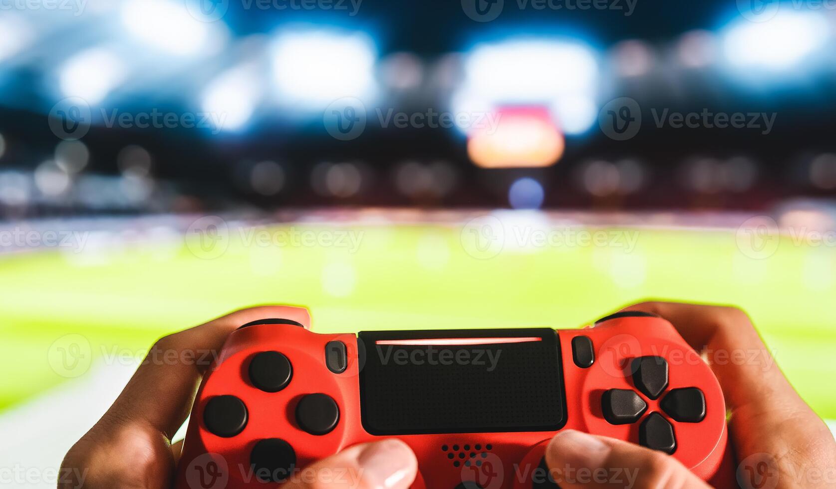 Young man having fun playing online soccer video games - Close up red magma game pad on tv background - Gaming entertainment and youth millennial generation lifestyle concept photo