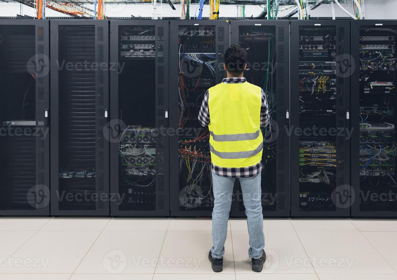 Male informatic engineer working inside server room database photo