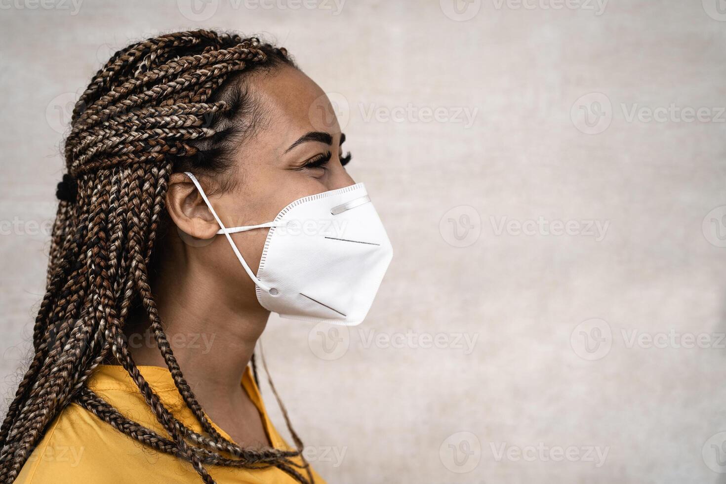 African woman with braids wearing face medical mask - Young girl using facemask for preventing and stop corona virus spread - Healthcare medical and youth millennial people concept photo