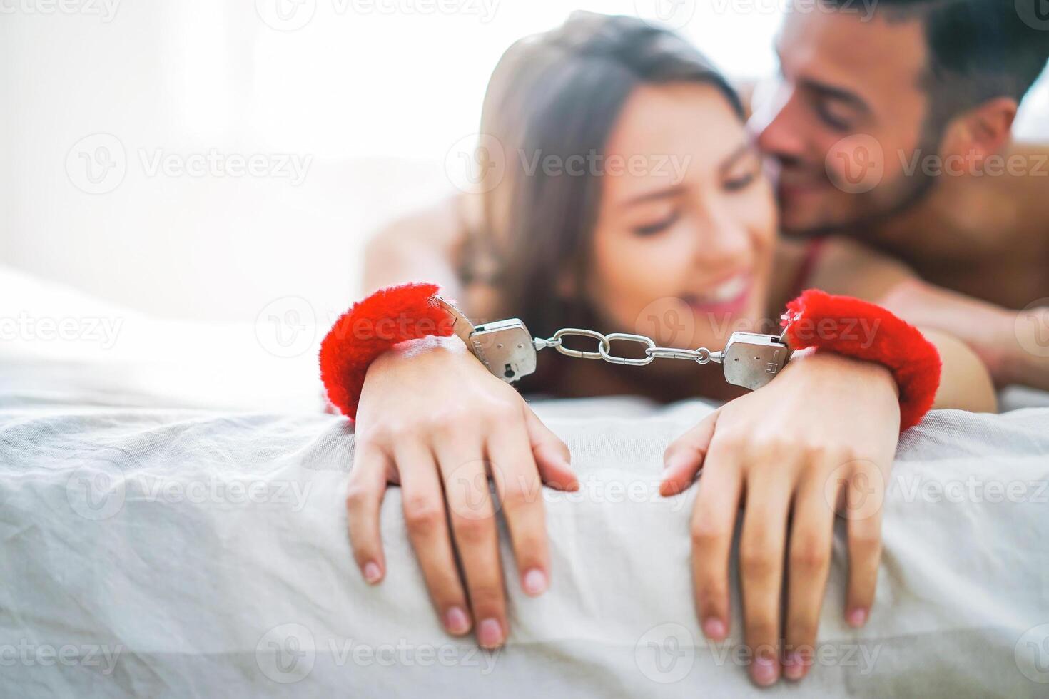 sexy Pareja jugando amor dominación juegos en el cama - tentación hombre y mujer teniendo erótico sexo en el dormitorio - gente, bdsm, erotismo y amante concepto foto