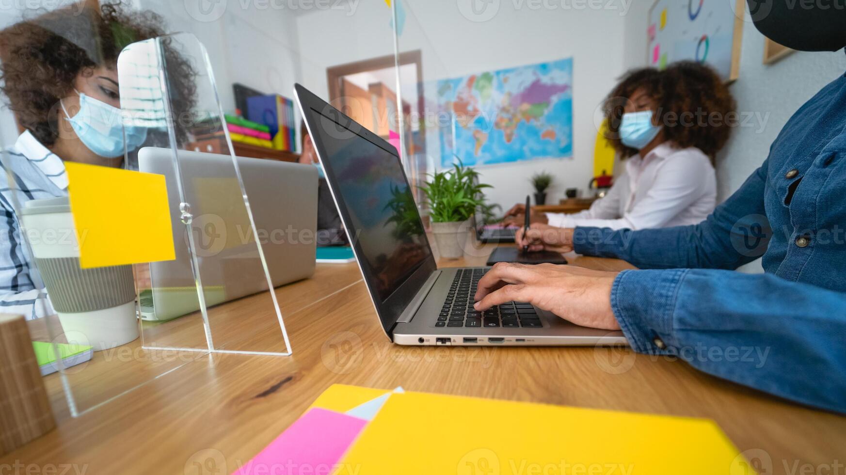 Young people in co-working creative space wearing surgical mask and keeping social distance to avoid corona virus spread - Health care and business technology concept photo