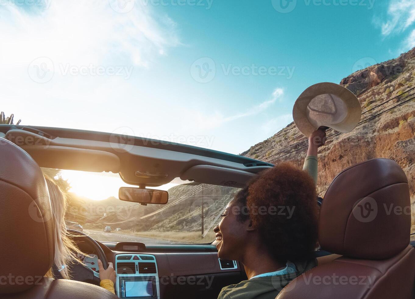 Young women doing road trip in tropical city - Travel happy people having fun driving in trendy convertible car discovering new places - Friendship and youth girlfriends vacation lifestyle concept photo