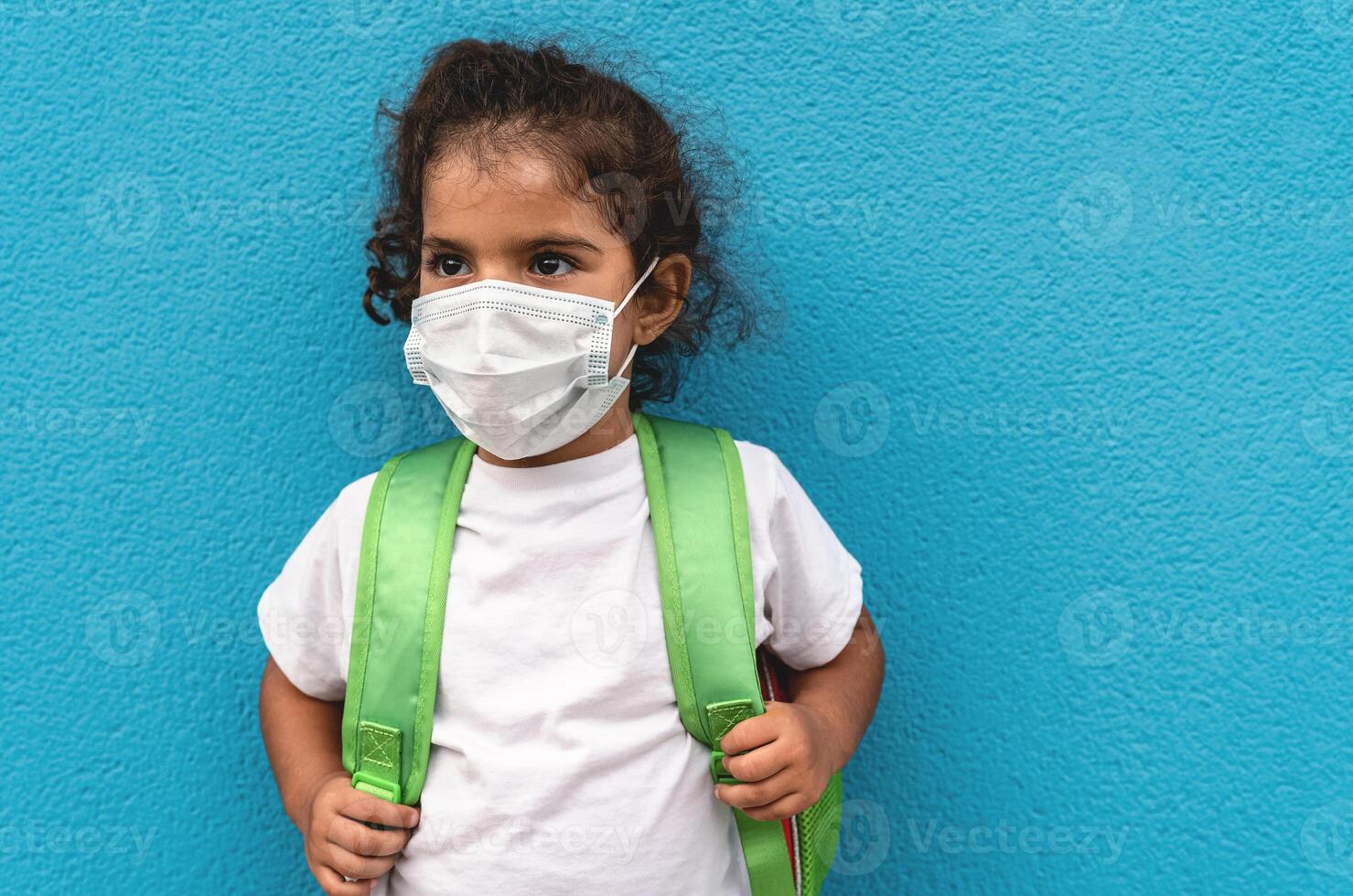 Child wearing face protective mask going back to school during corona virus pandemic - Healthcare and education concept photo