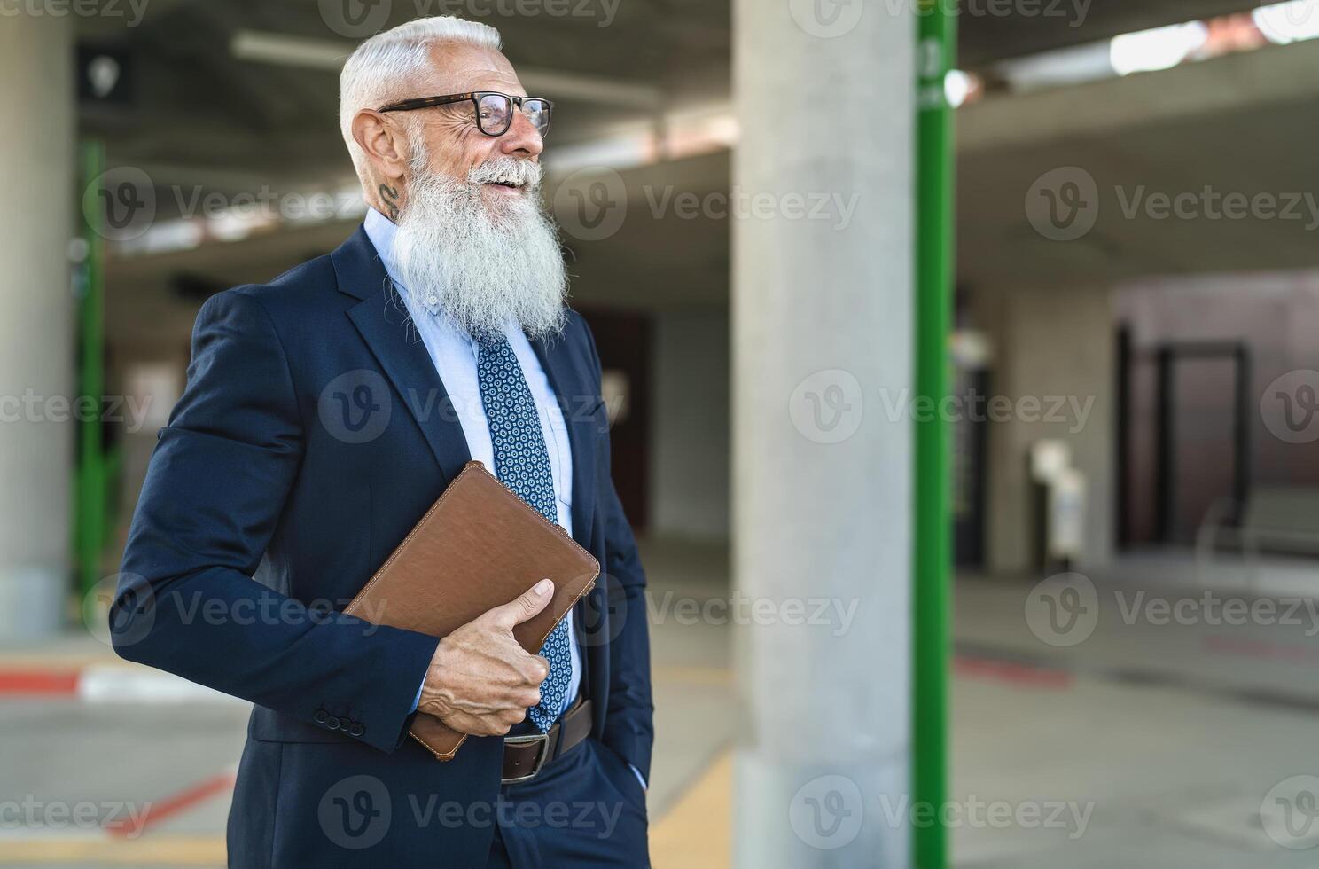 Happy senior business man holding digital tablet waiting in city bus station photo