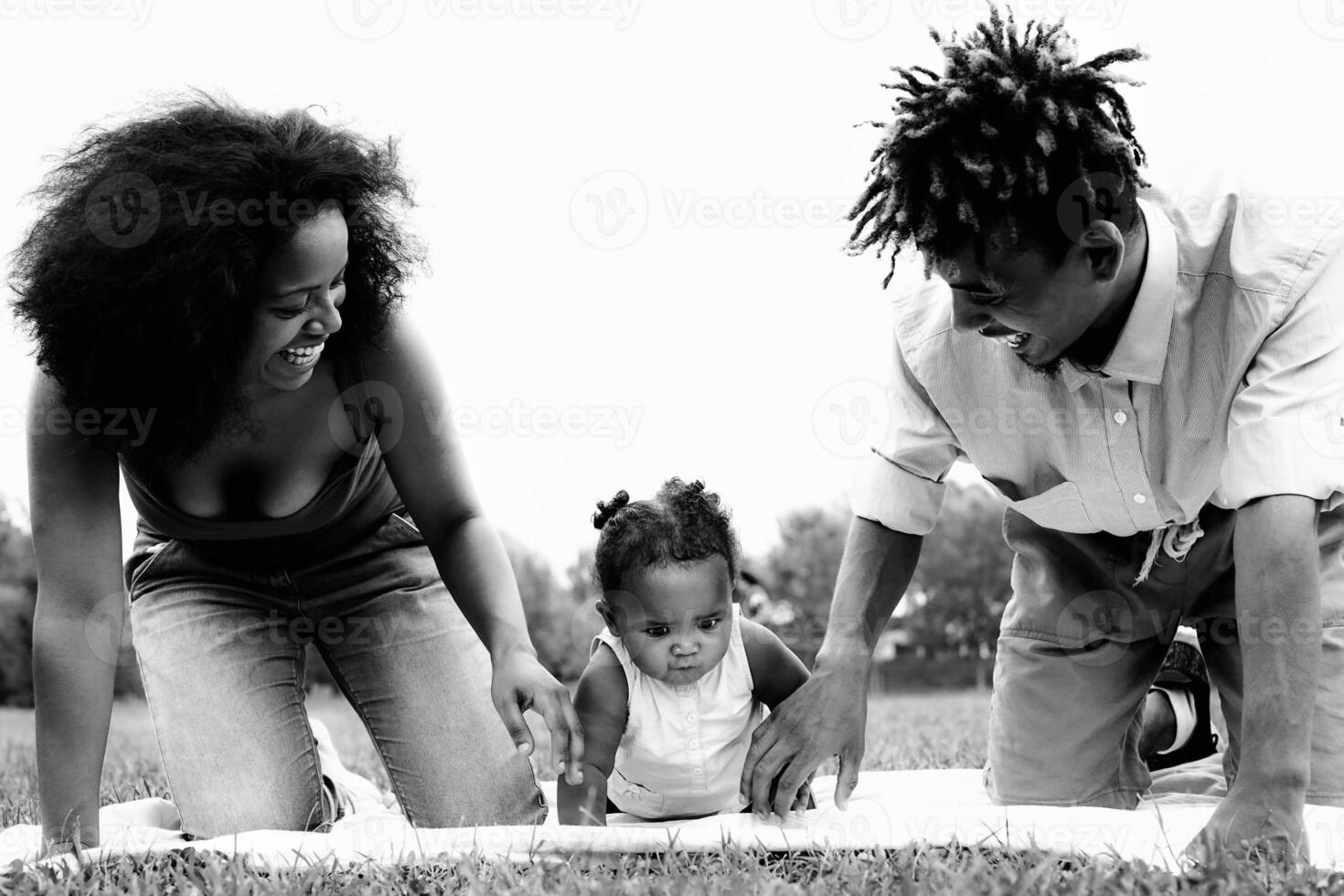 Happy African family having fun together in public park - Black father and mother enjoying time with their daughter photo
