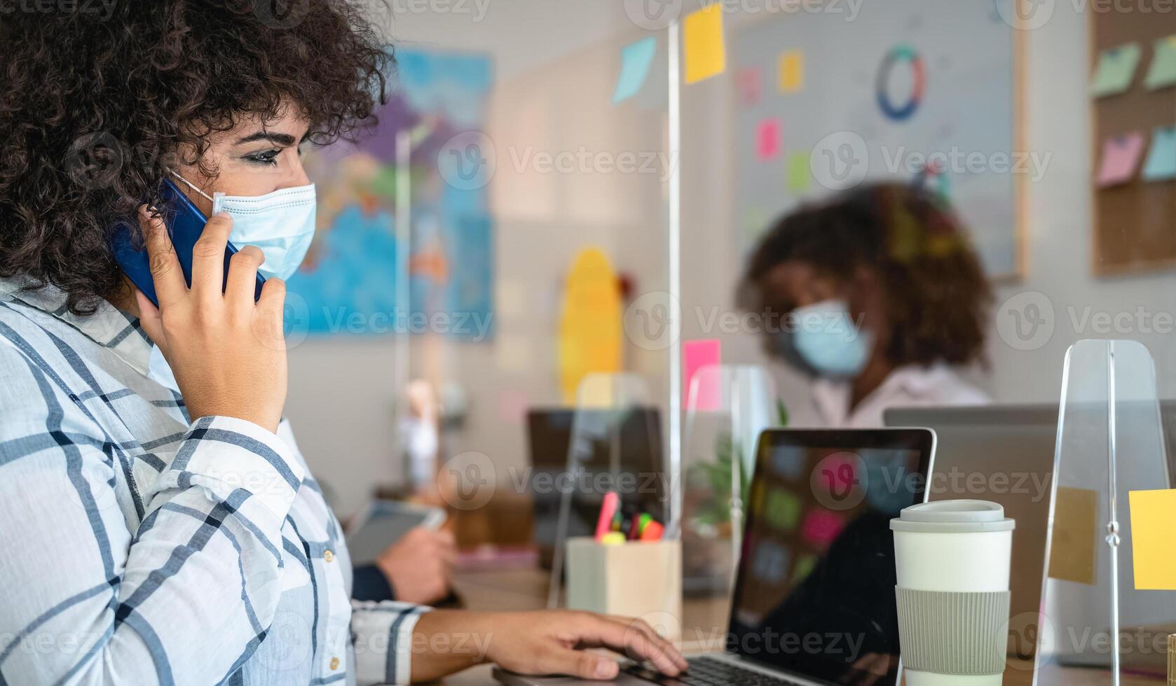 Young people in co-working creative space wearing surgical mask protection and keeping social distance to avoid corona virus spread - Health care and business technology concept photo