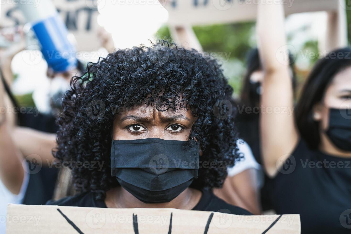 Young Afro woman activist protesting against racism and fighting for equality - Black lives matter demonstration on street for justice and equal rights photo