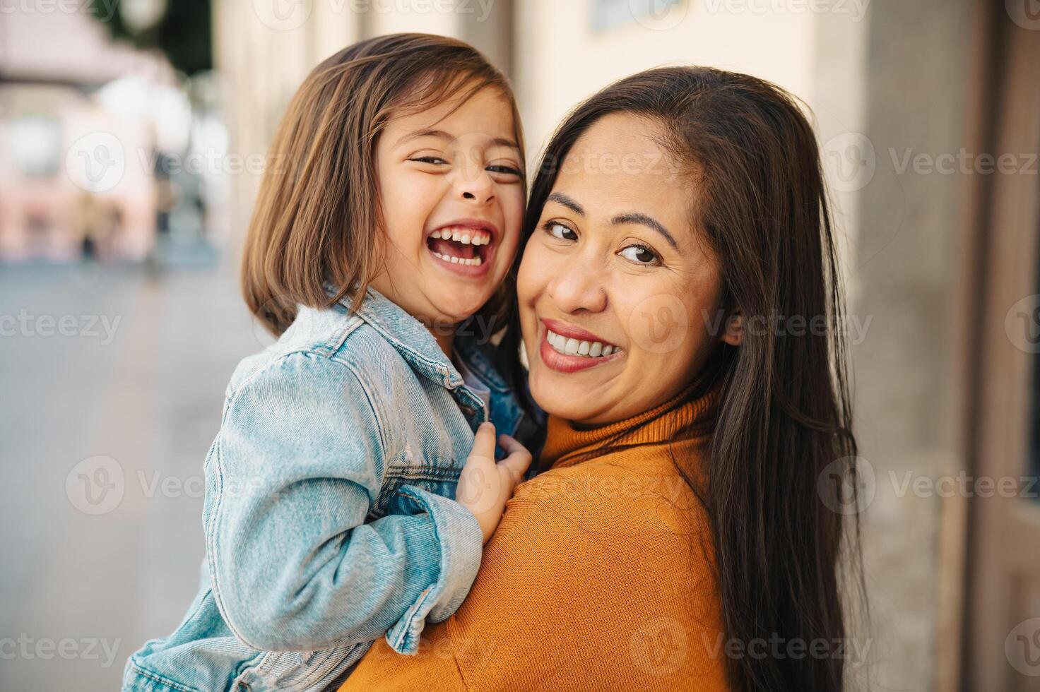 Happy southeast Asian mother with her daughter having fun in the city center - Lovely family outdoor photo