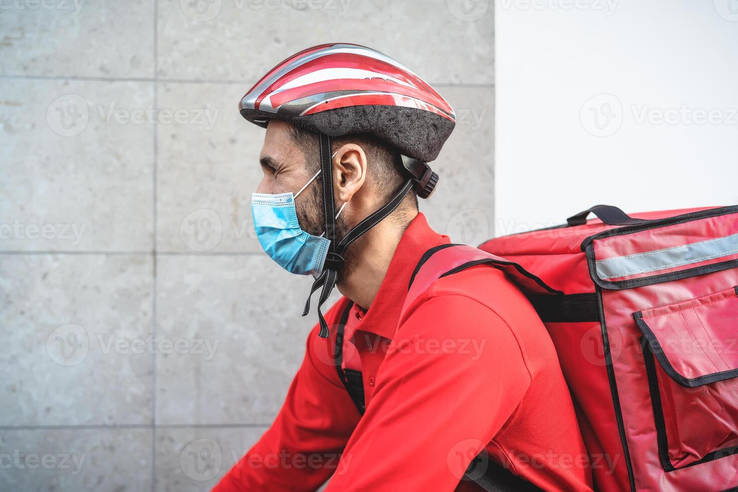 jinete hombre entregando comida a clientes con eléctrico bicicleta mientras vistiendo cara máscara durante corona virus brote - eco rápido entrega comida concepto foto