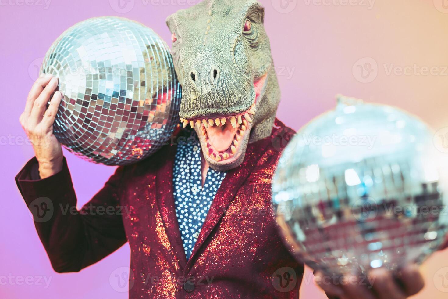 Senior man having fun wearing t-rex mask in discotheque - Elegant dinosaur masquerade male celebrating carnival party inside disco club - Funny absurd holidays and crazy people humor lifestyle concept photo