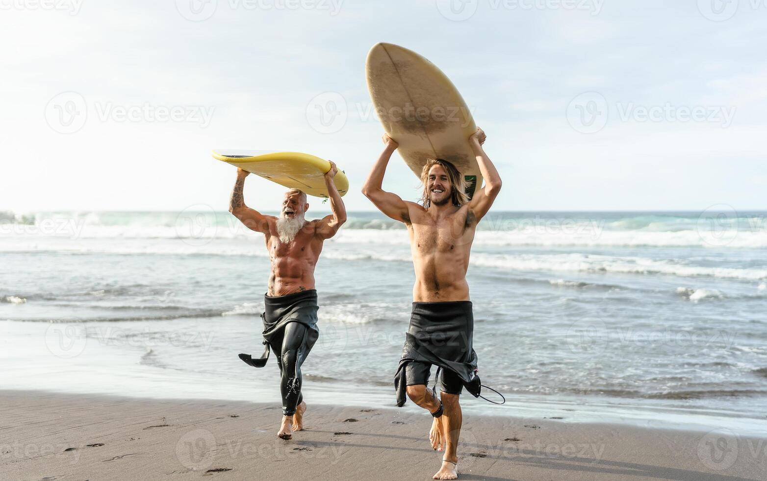 Happy friends with different age surfing together - Sporty people having fun during vacation surf day - Extreme sport lifestyle concept photo