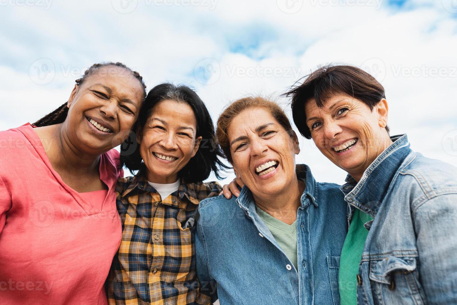 Happy multiracial senior women having fun smiling into the camera at house rooftop photo