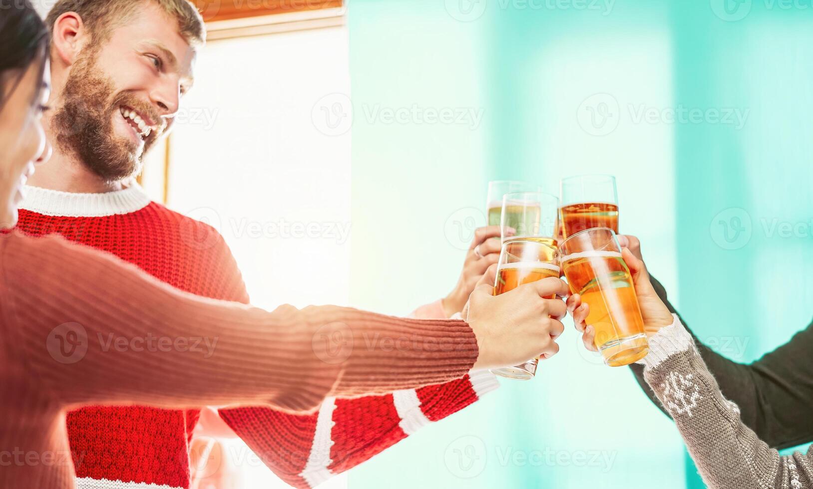 Happy friends doing celebratory toast in winter Christmas holidays - Young people drinking beer in xmas time - Youth culture lifestyle and traditional event celebration concept photo