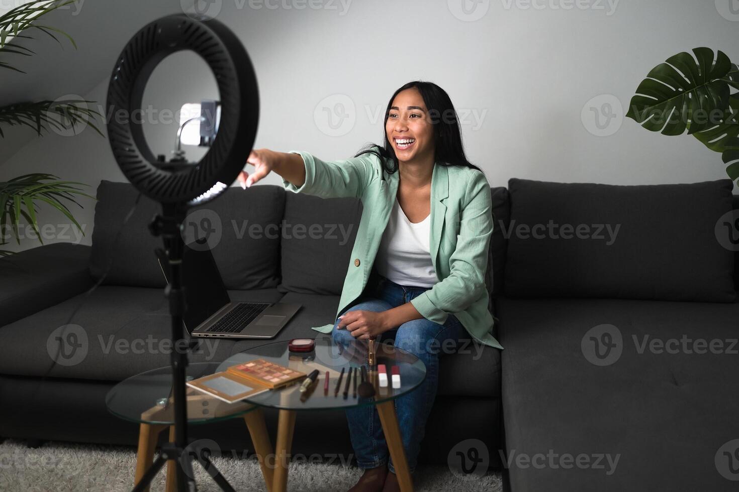 joven mujer vlogging en línea con teléfono inteligente leva y anillo LED desde hogar vivo habitación - juventud personas con social medios de comunicación y inteligente trabajando concepto foto