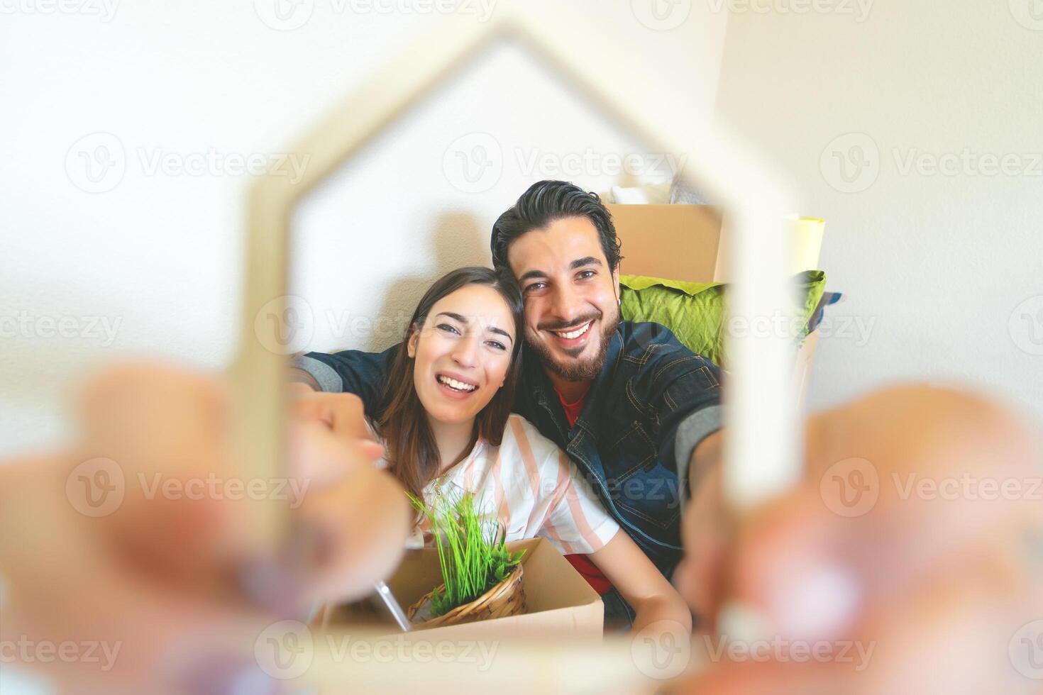 Happy young couple moving in new home first time - Man and woman having fun unpacking carton box in new property house - Change apartment day and people lifestyle relationship concept photo