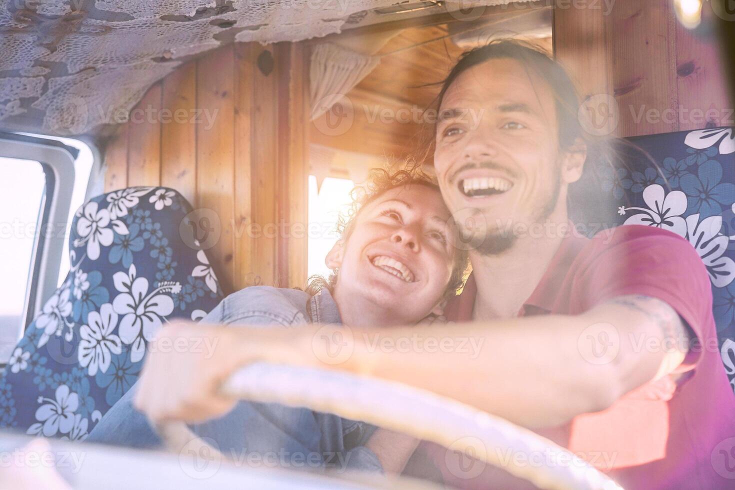 Happy smiling couple inside a vintage minivan - Travel people excited driving for a road trip with a van camper - Vacation, love, relationship lifestyle concept photo