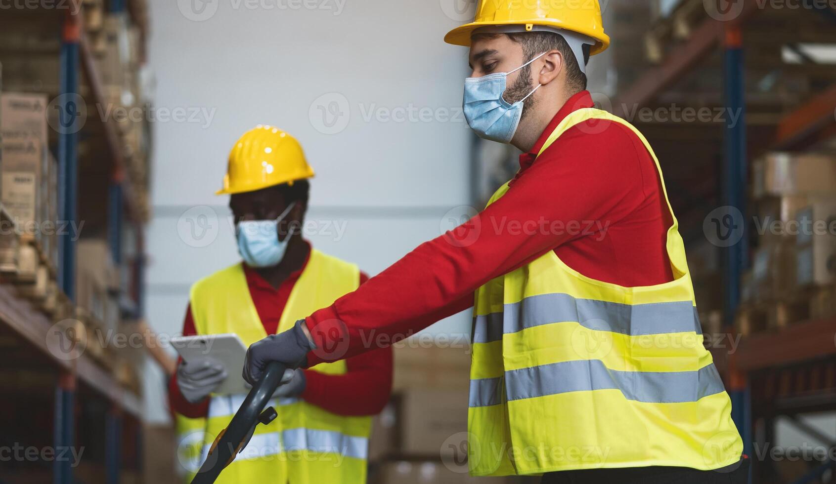 Team working in warehouse doing inventory using digital tablet loading delivery boxes while wearing face mask during corona virus pandemic - Logistic and industry concept photo