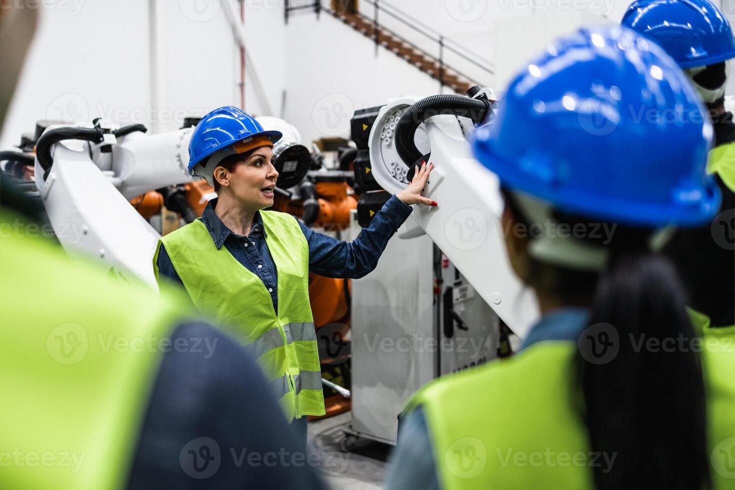 Team of engineers working in robotic factory - Tech industry concept photo