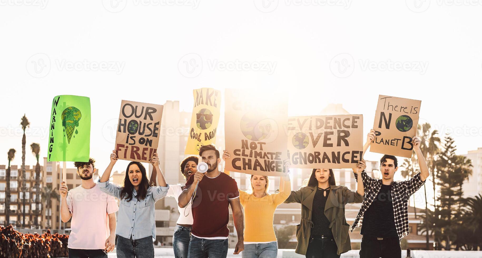 Demonstrators group protesting against plastic pollution and climate change - Multiracial people fighting on road holding banners on environments disasters - Global warming concept photo