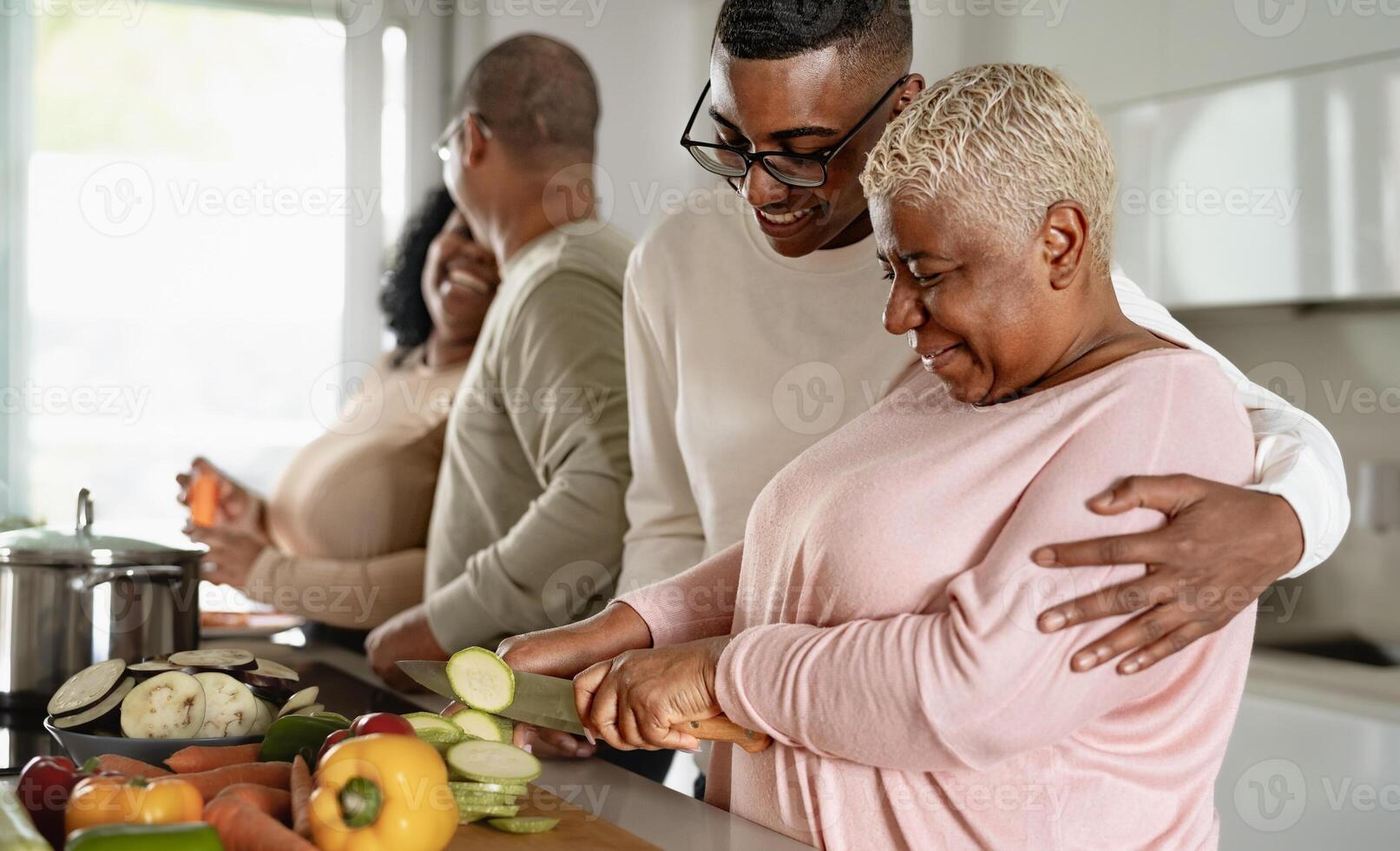 Happy African family preparing food recipe together in modern kitchen - Food and parents unity concept photo