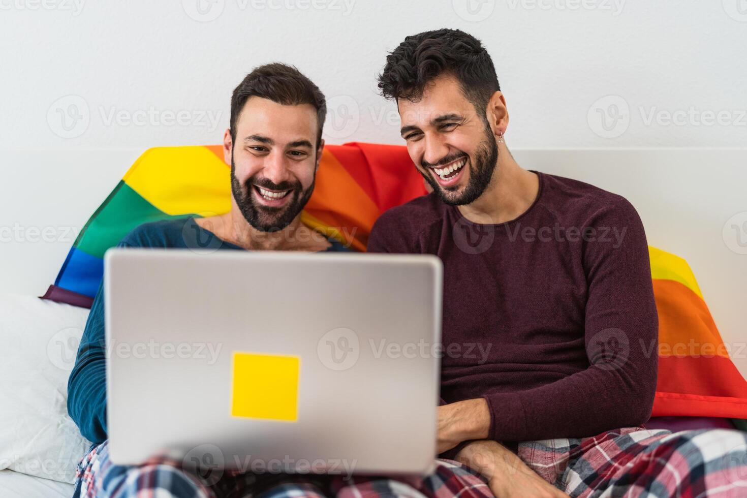 Happy gay men couple using laptop in bed - Homosexual love and gender equality in relationship concept photo