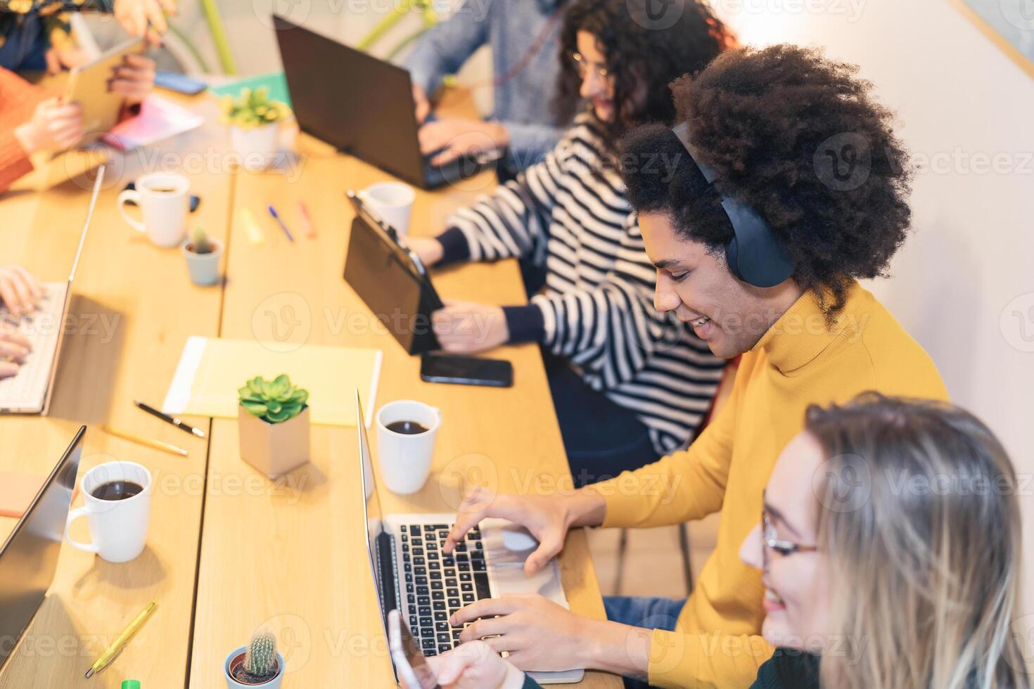 Happy young people working together inside office - Multiracial friends having fun collaborating in coworking space - Youth co-workers millennial generation lifestyle and technology workspace concept photo
