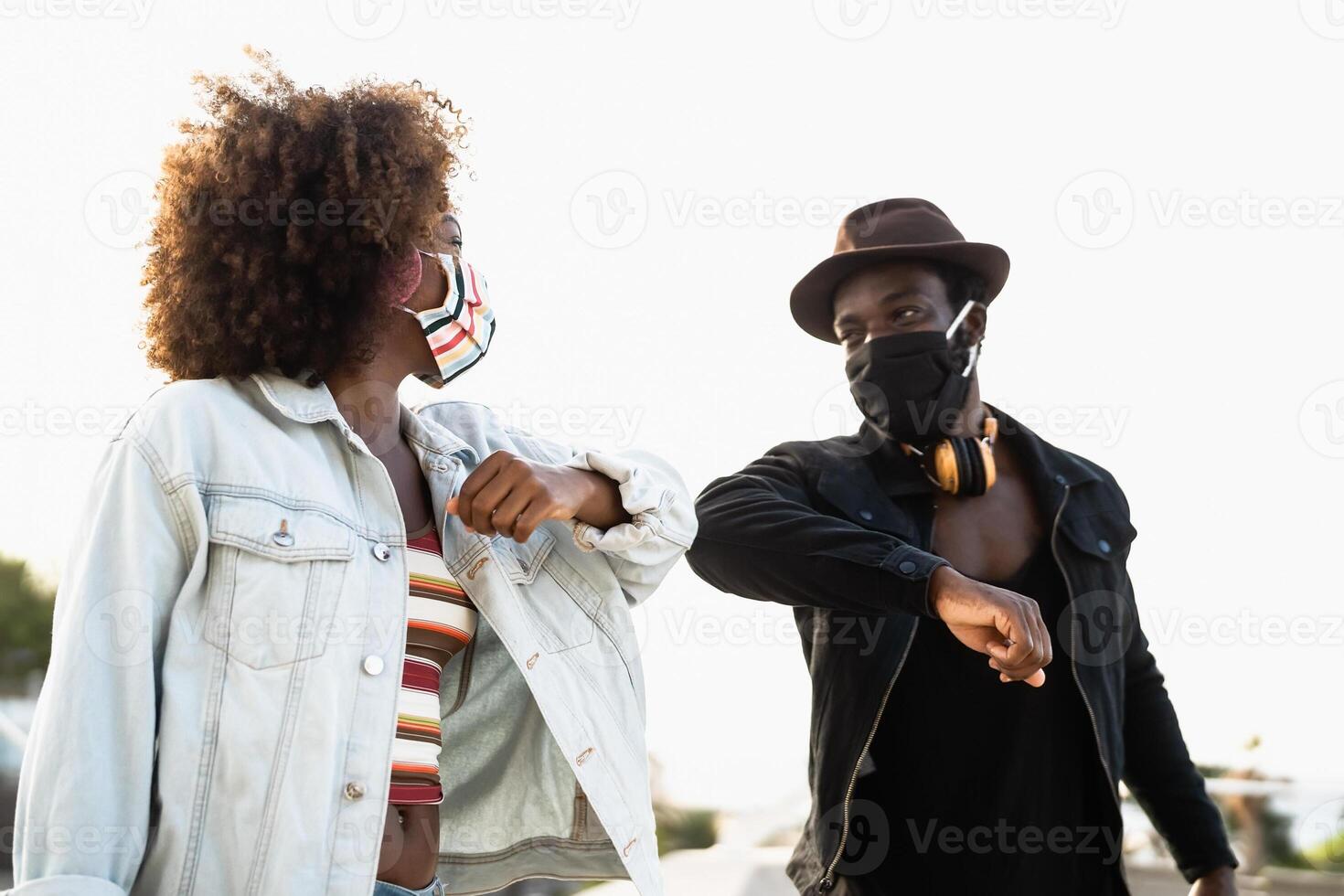 afro americano amigos vistiendo cara máscara al aire libre foto