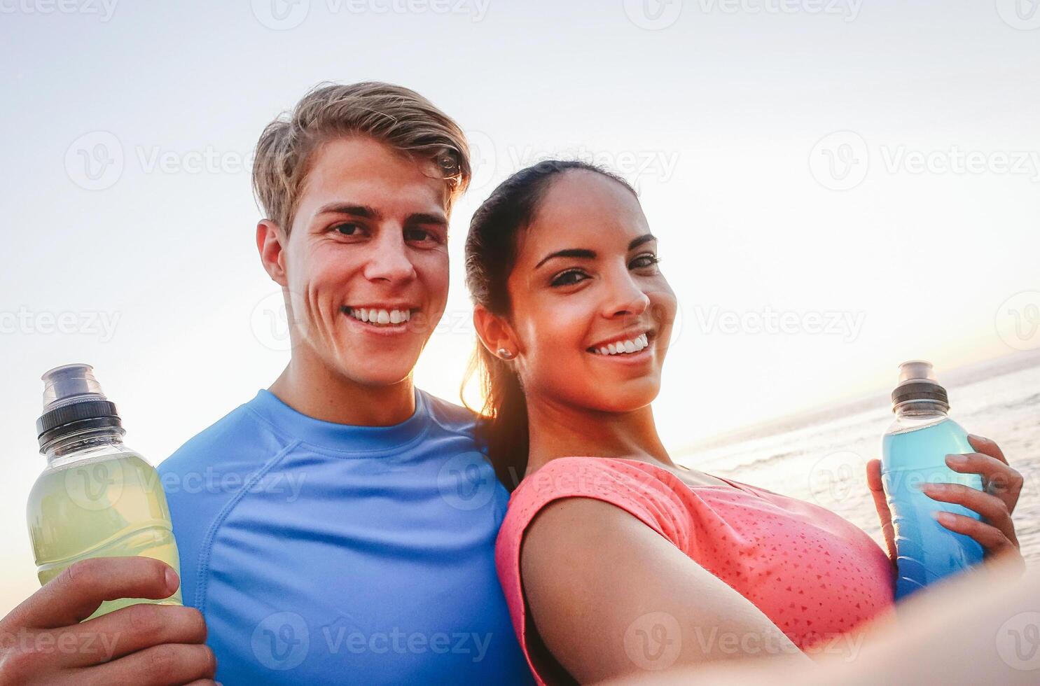 deportivo Pareja tomando un selfie con móvil teléfono a puesta de sol - joven personas teniendo un descanso desde formación y Bebiendo energía bebidas - deporte, relación, sano estilo de vida concepto foto