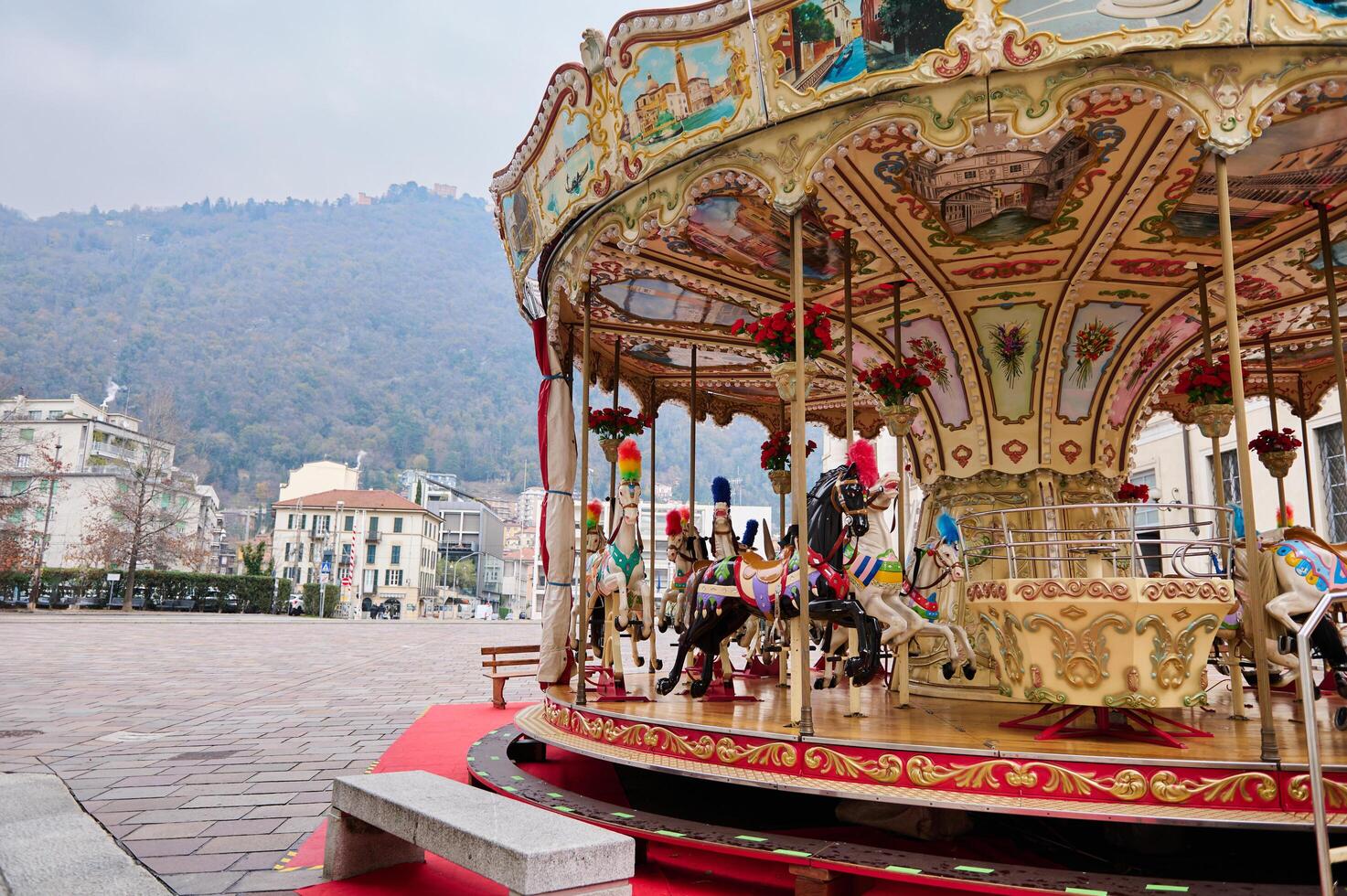 un alegre Vamos redondo, victoriano carrusel a Navidad recinto ferial en como, en contra italiano Alpes fondo en nublado invierno día foto