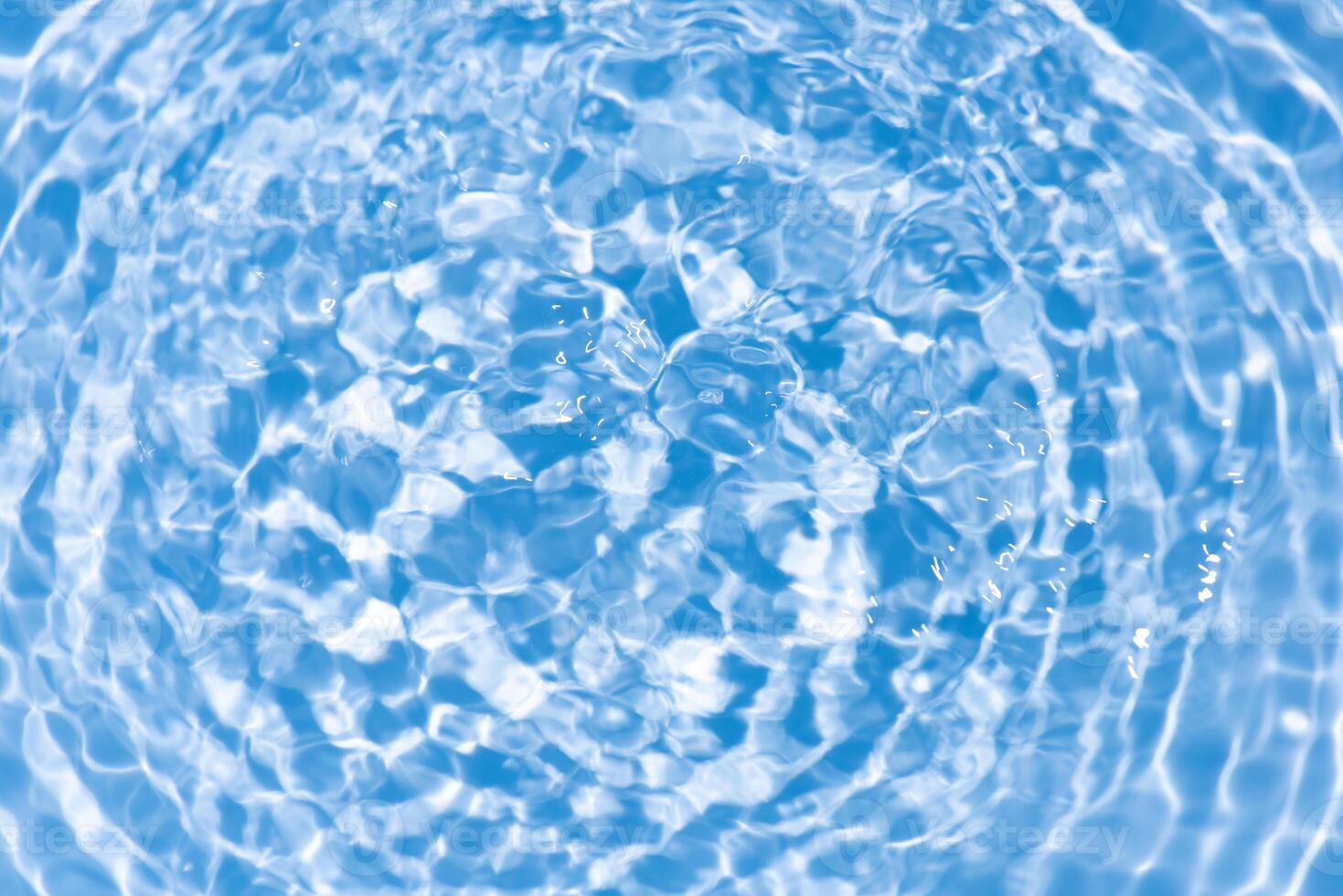 Bluewater waves on the surface ripples blurred. Defocus blurred transparent blue colored clear calm water surface texture with splash and bubbles. Water waves with shining pattern texture background. photo