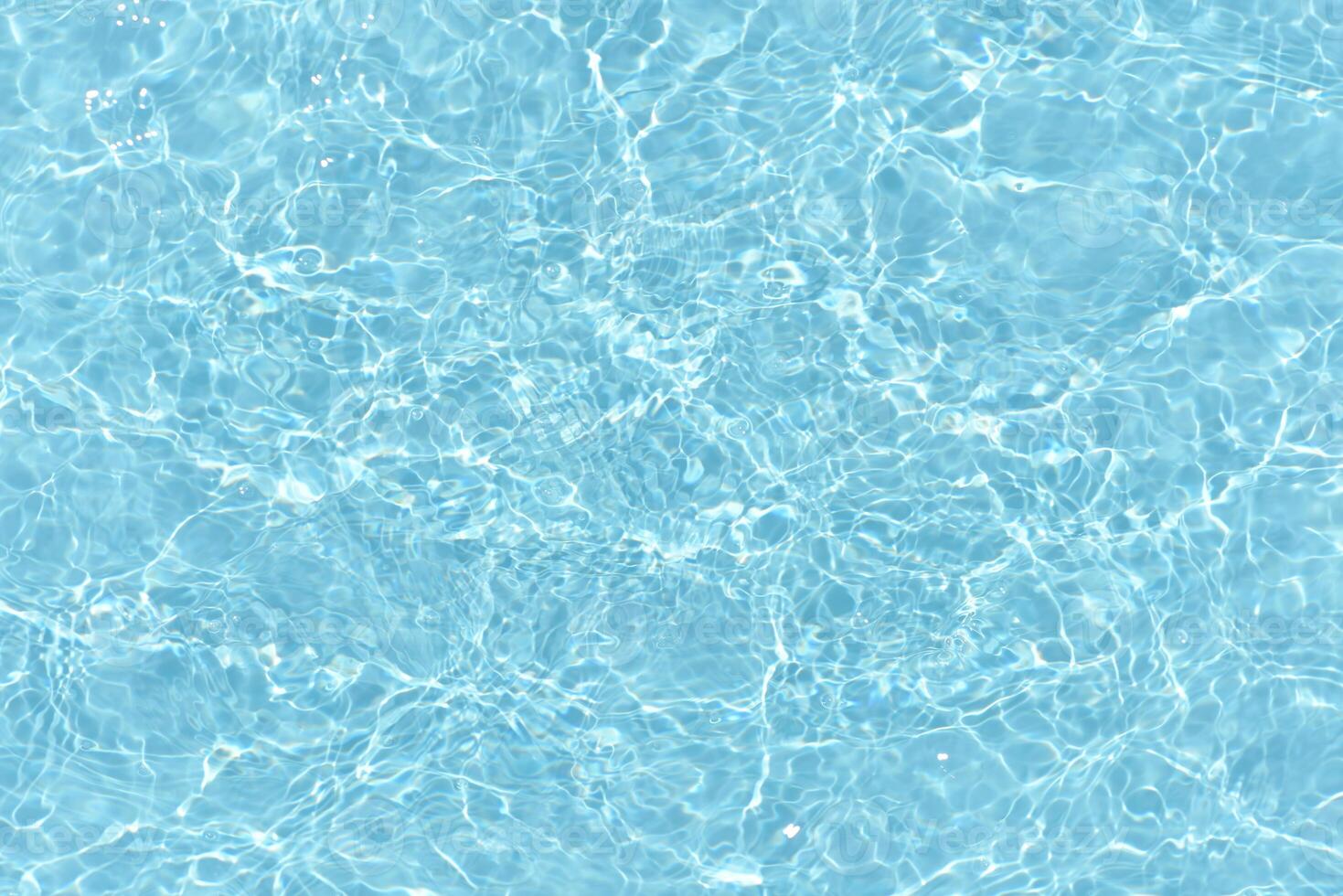 Bluewater waves on the surface ripples blurred. Defocus blurred transparent blue colored clear calm water surface texture with splash and bubbles. Water waves with shining pattern texture background. photo