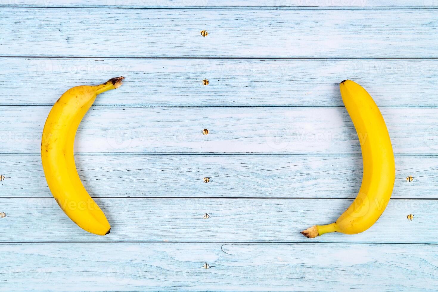 Yellow bananas lie on a blue wooden background.Summer concept photo