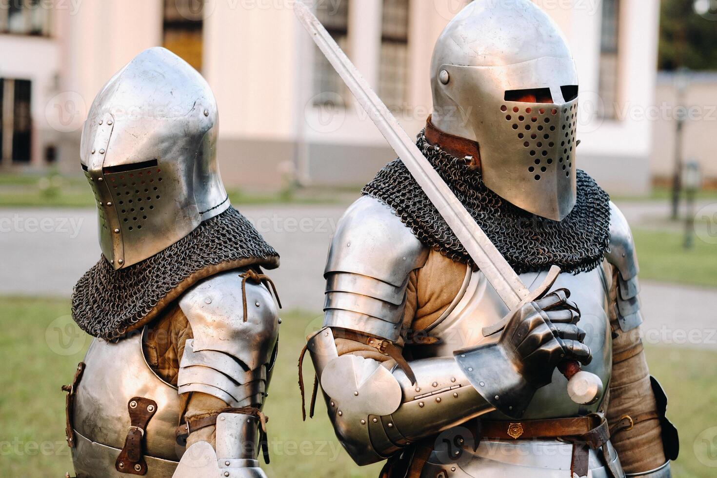 Two knights in armor on the background of a medieval castle.A medieval concept.Metallic texture photo