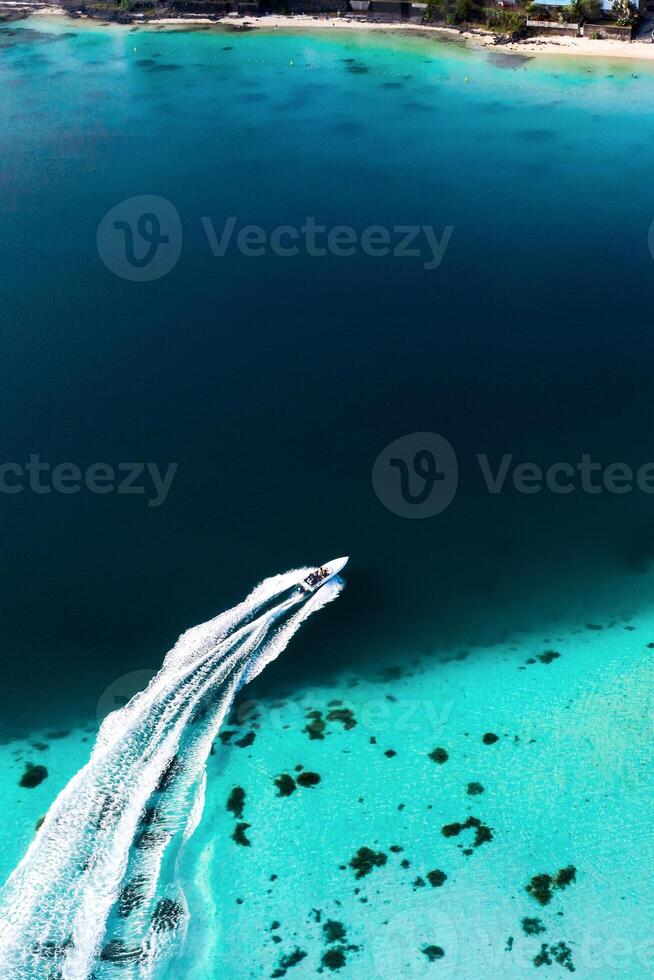 parte superior ver de el azul bahía laguna de mauricio un barco flotadores en un turquesa laguna foto