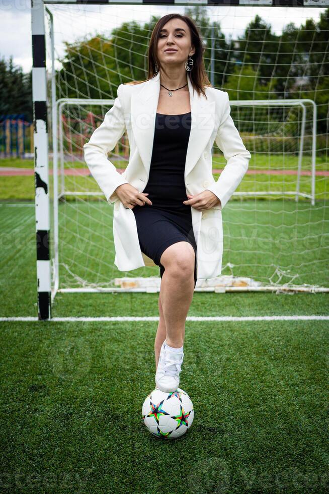 retrato de un hermosa mujer fútbol americano jugador en un estricto oficina traje. foto