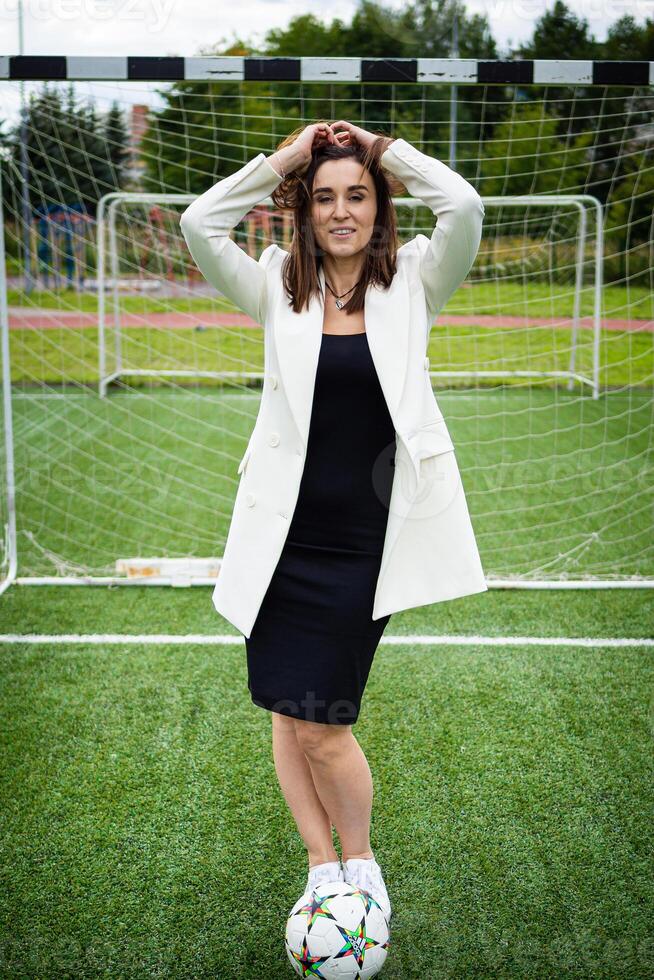 retrato de un hermosa mujer fútbol americano jugador en un estricto oficina traje. foto