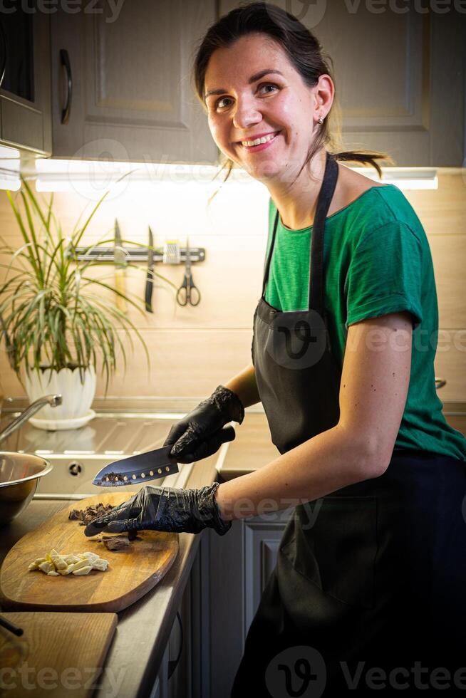 Woman cooking tasty melted chocolate on table in kitchen. photo