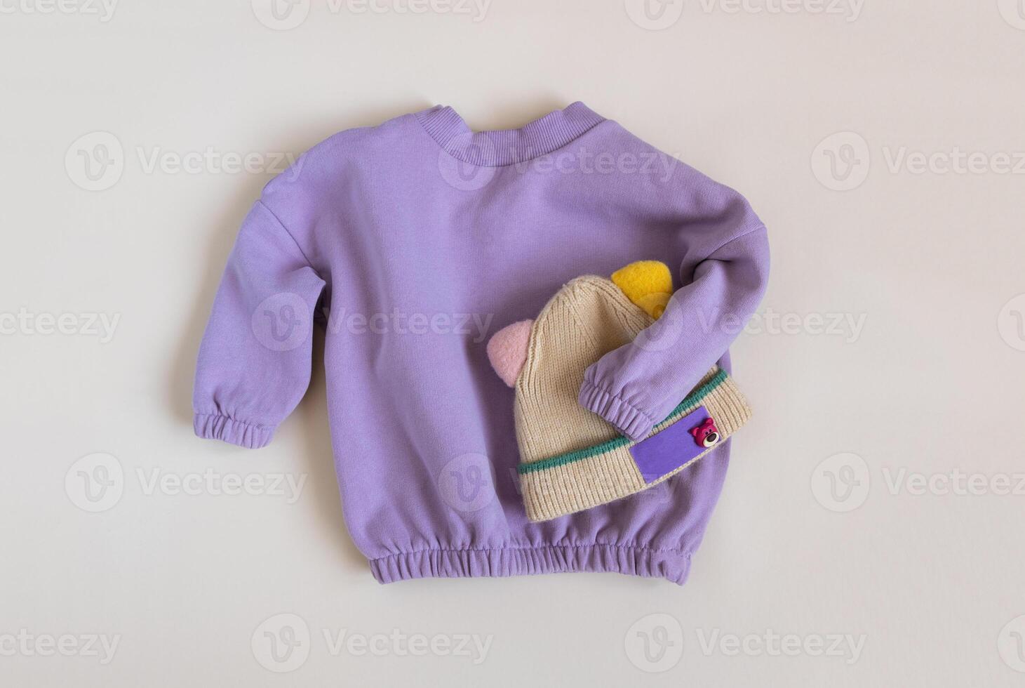 Stylish children's spring lilac sweatshirt and funny hat. Fashion kids outfit for for spring, autumn or winter. Flat lay, top view photo