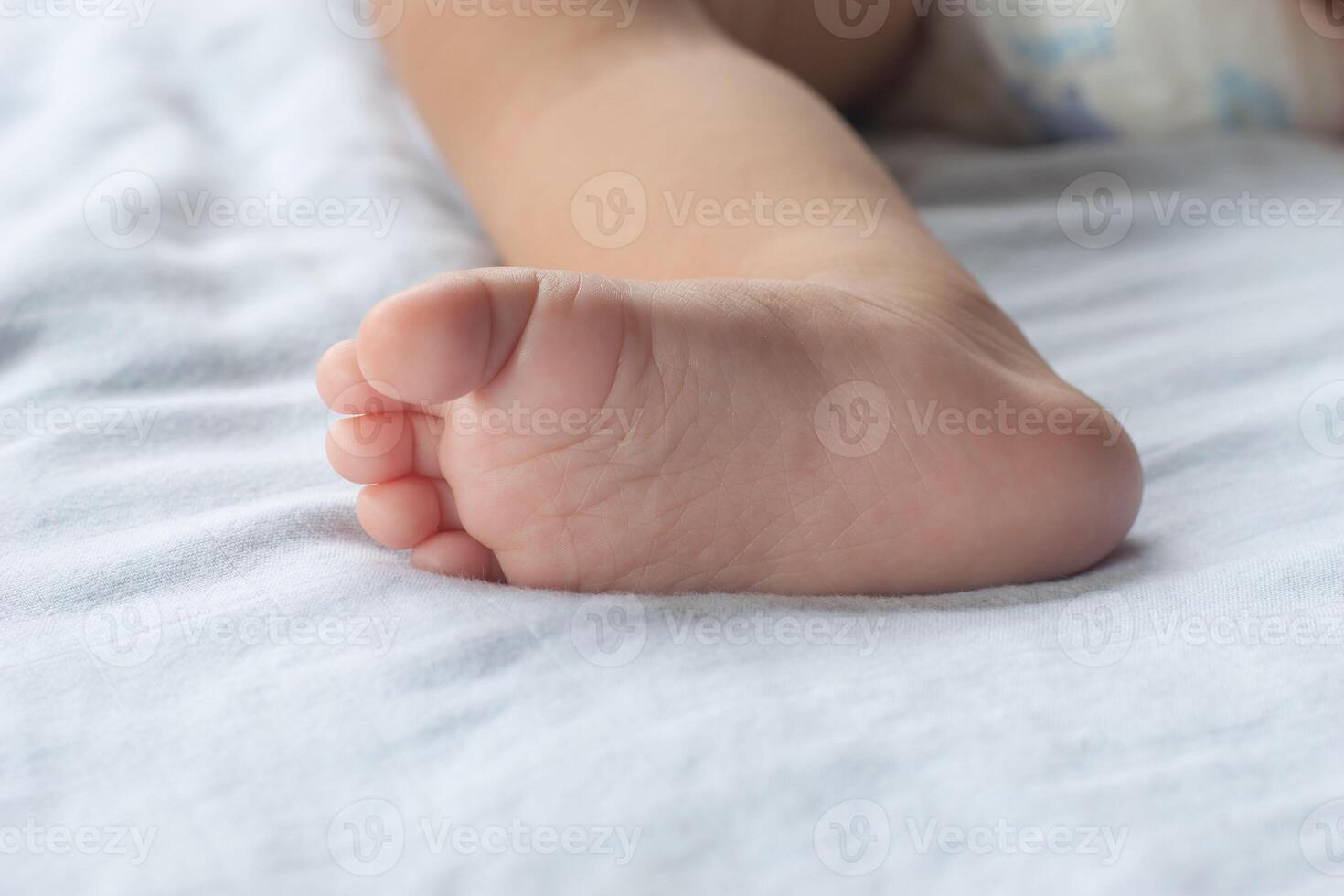 Close-up of soft baby's feet on mattress. photo