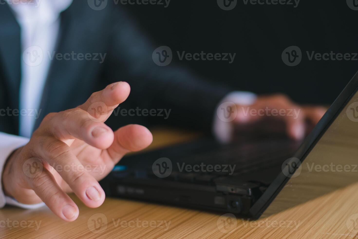 Close-up of a businessman working with a notebook computer and pointing out his hand. photo