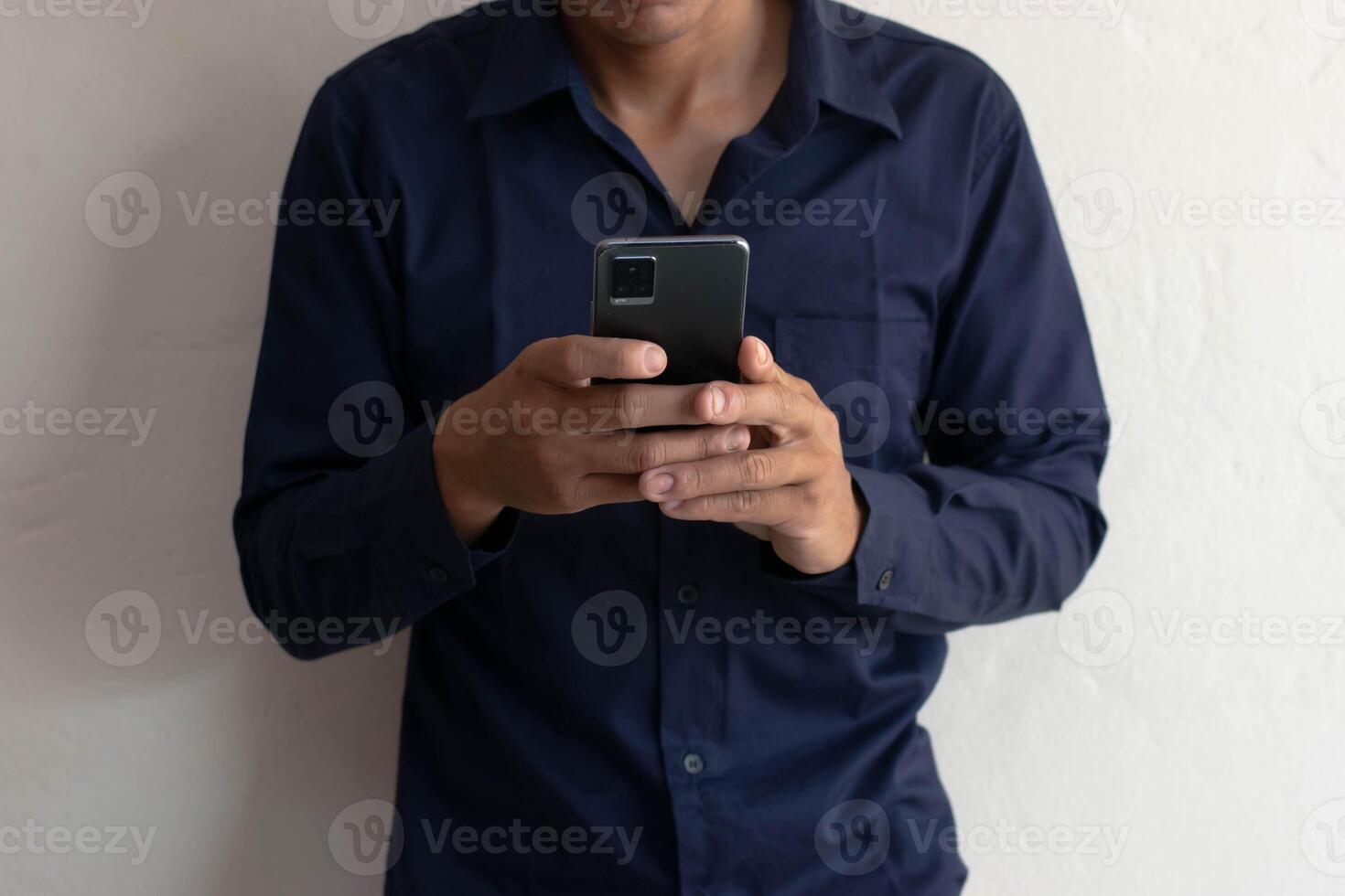 Man playing mobile phone in house, typing messages, chatting online, surfing the internet. photo