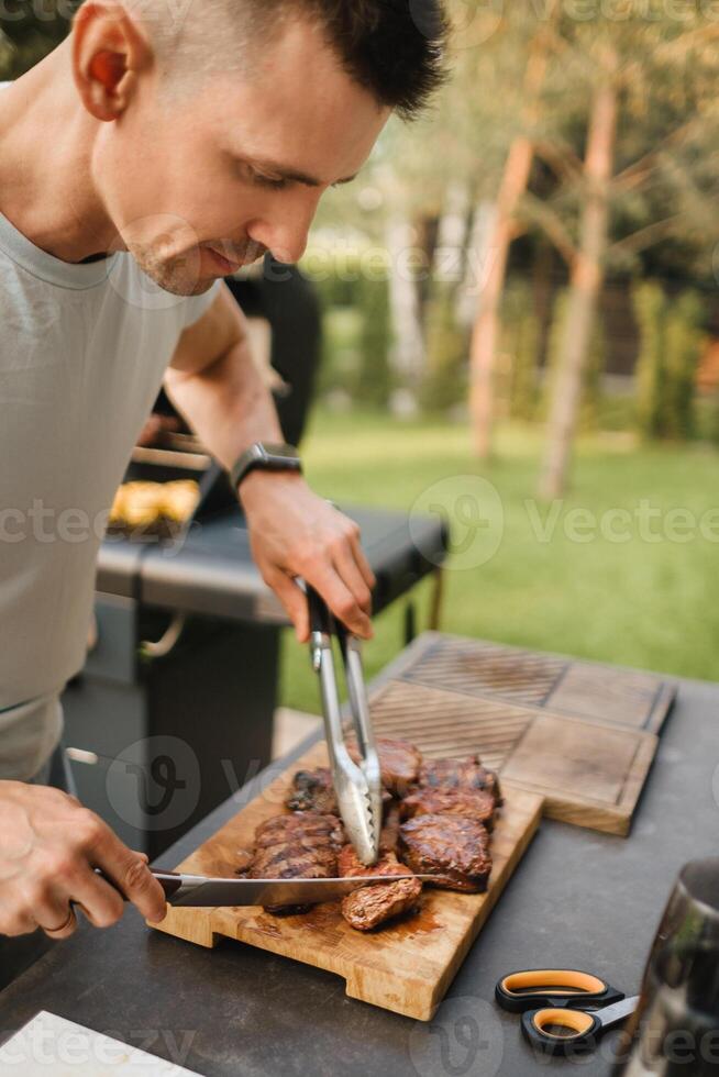 un hombre en el calle cocido un filete en el parrilla en un parilla foto