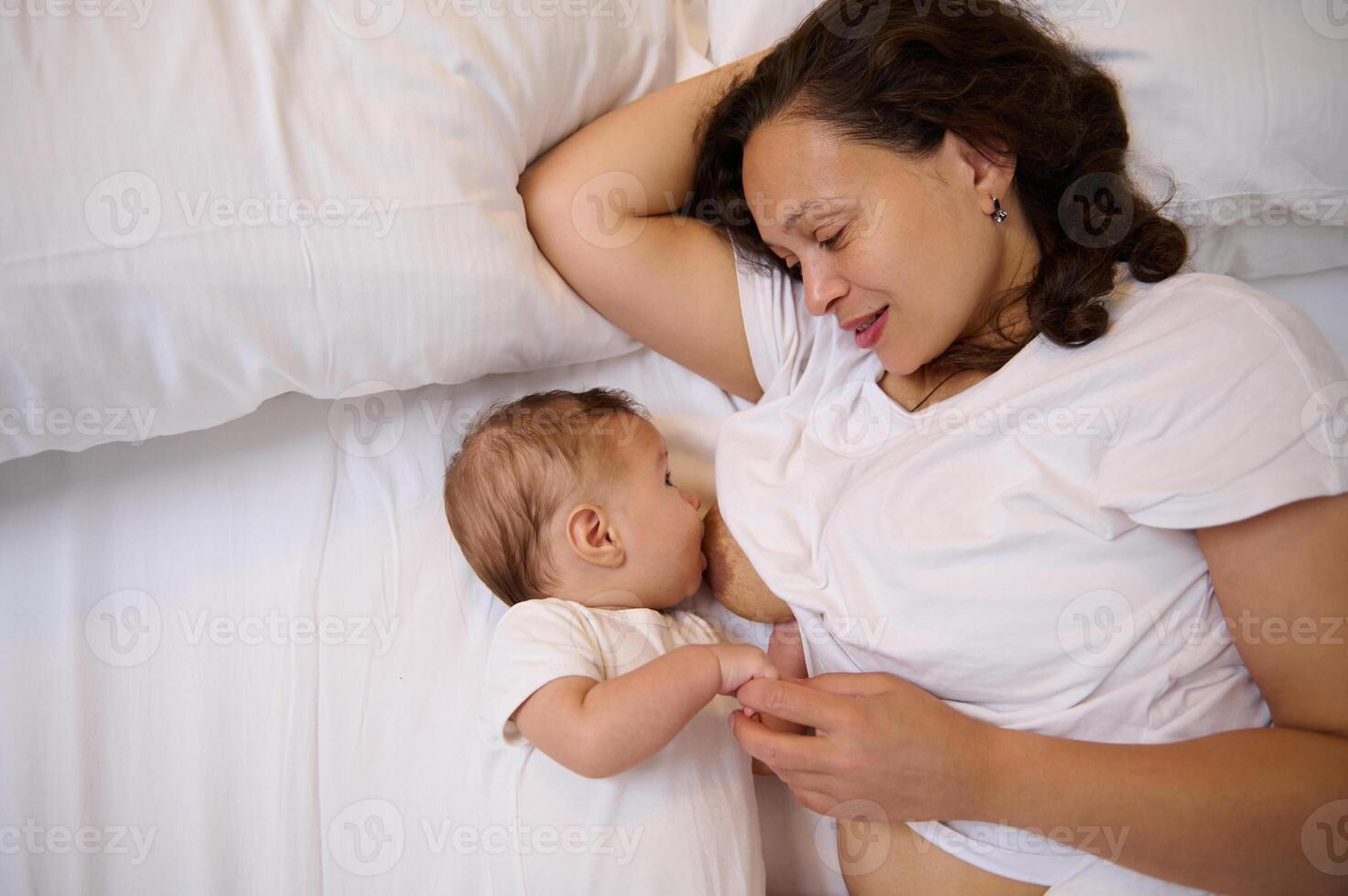 Overhead view happy young mother breastfeeding her newborn baby photo