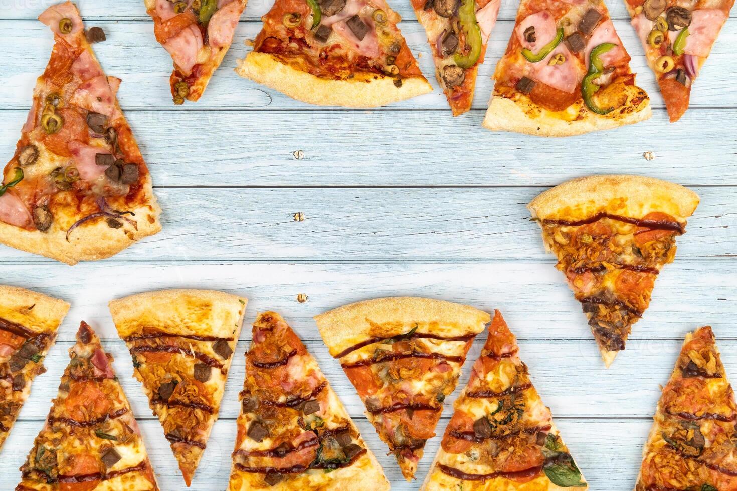 Lots of delicious triangular pizza slices on a blue wooden background photo