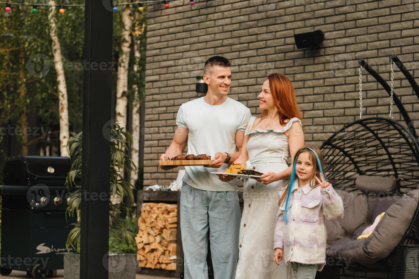 un contento familia tiene preparado almuerzo y será comer a su casa. retrato de un familia con comida en su manos foto