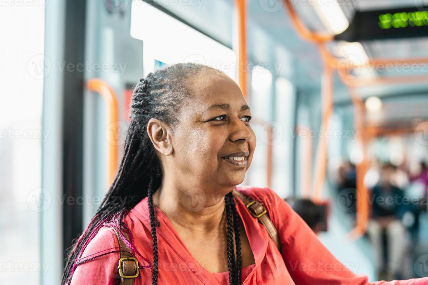 Happy African senior woman traveling with public tram photo