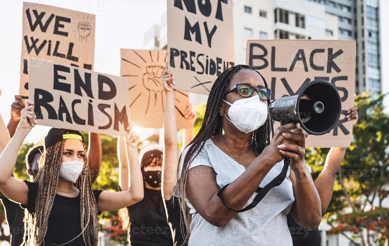 Activist movement protesting against racism and fighting for equality - Demonstrators from different cultures and race protest on street for equal rights - Black lives matter protests city concept photo