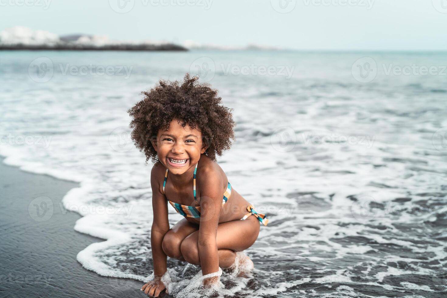 afro americano niño teniendo divertido en el playa - pequeño niño jugando durante verano hora al aire libre - negro personas y vacaciones concepto foto